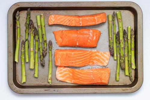 salmon and asparagus on a baking sheet